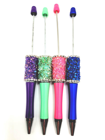 Four colorful pens with glittery accents on a white background