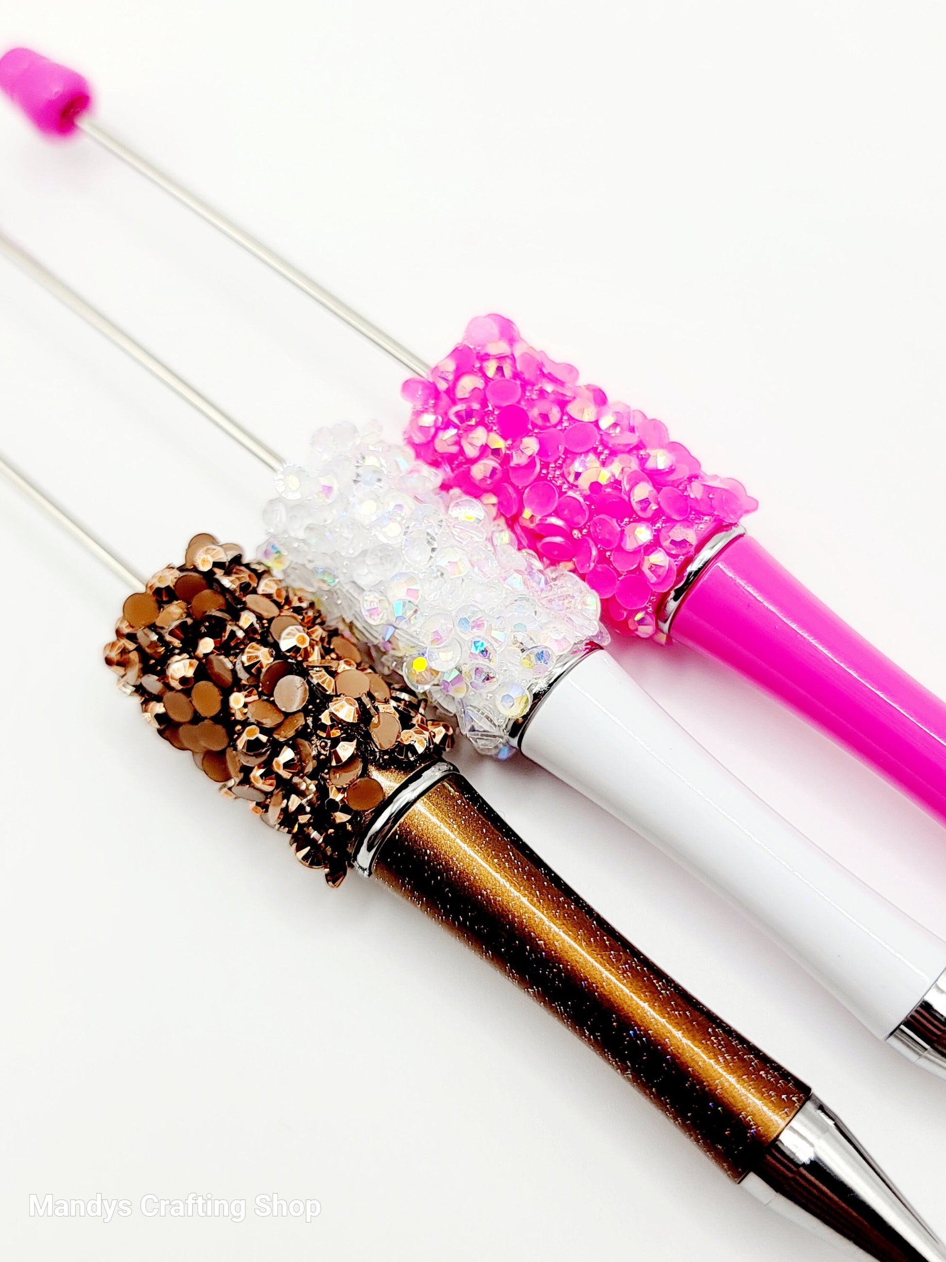 Decorative pens with glittery accents on a white background