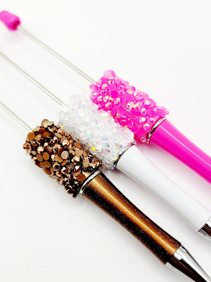 Decorative pens with glittery accents on a white background