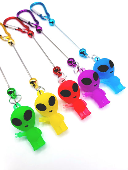 Colorful alien-shaped keychains with carabiners on a white background