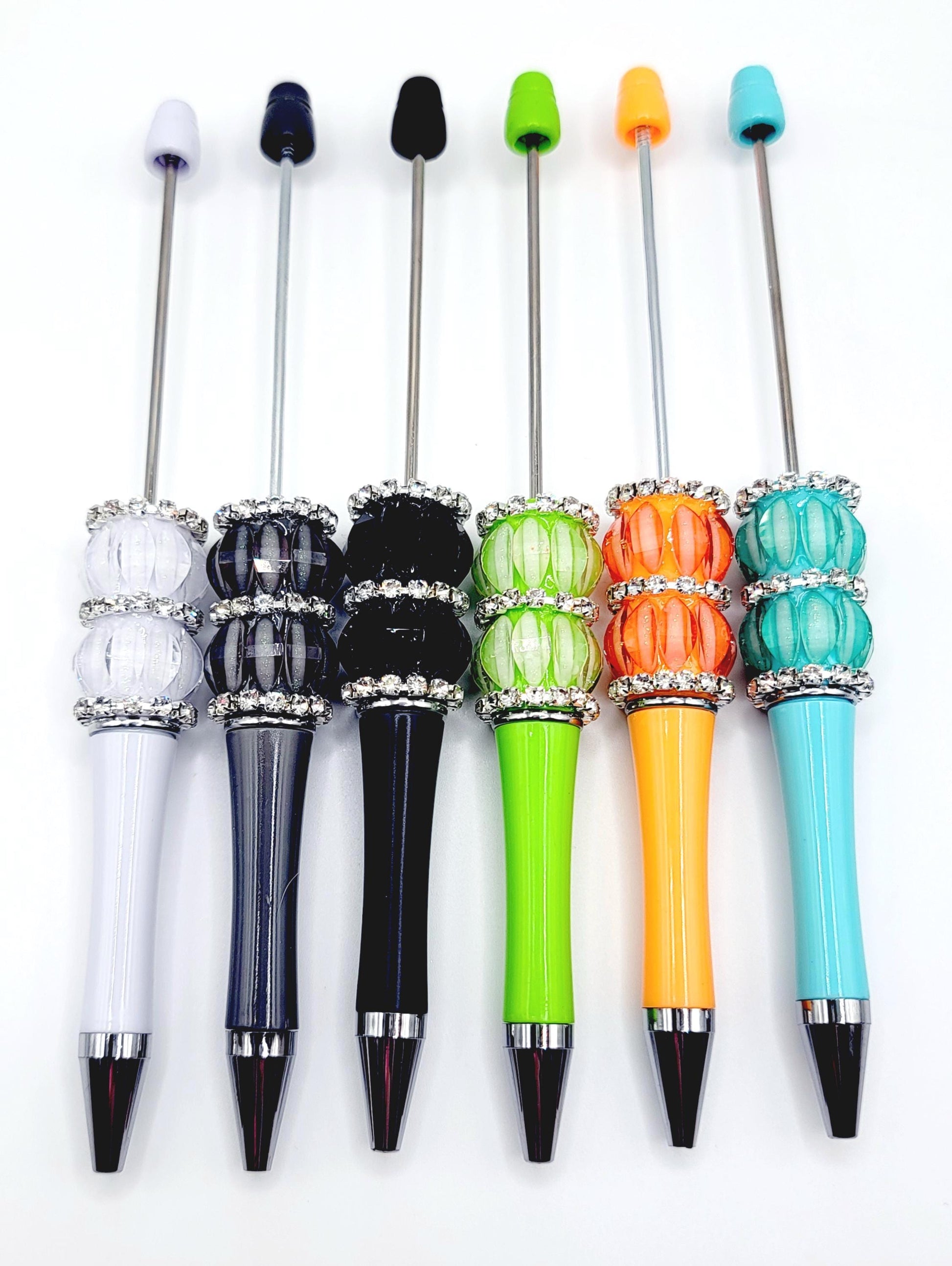 Set of colorful pens with decorative caps on a white background