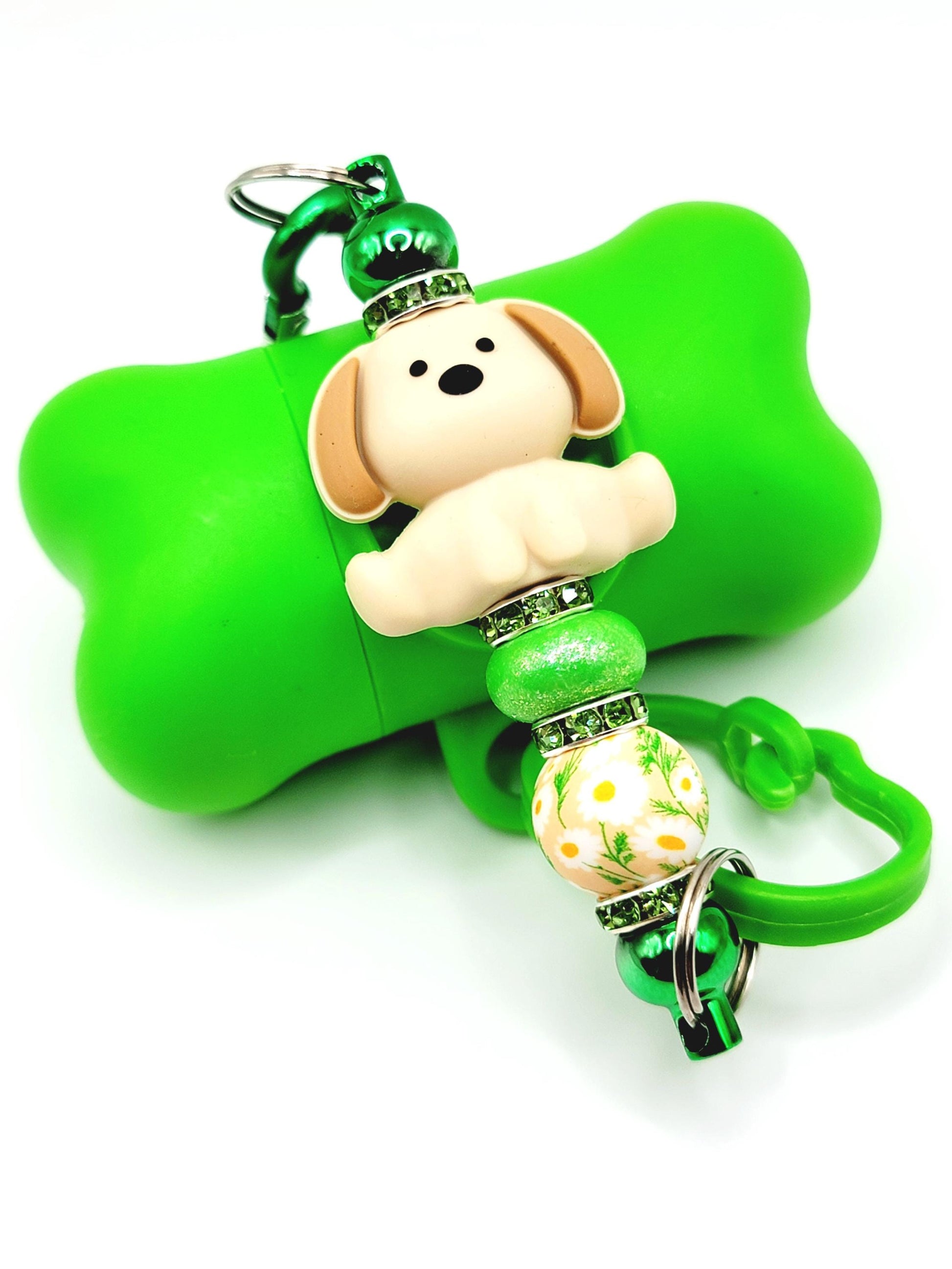Green dog bone-shaped keychain with a small dog figure and decorative bead on a white background