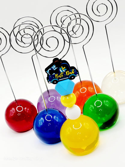 Colorful plastic balls on sticks with a 'Best Dad' car design, on a white background.
