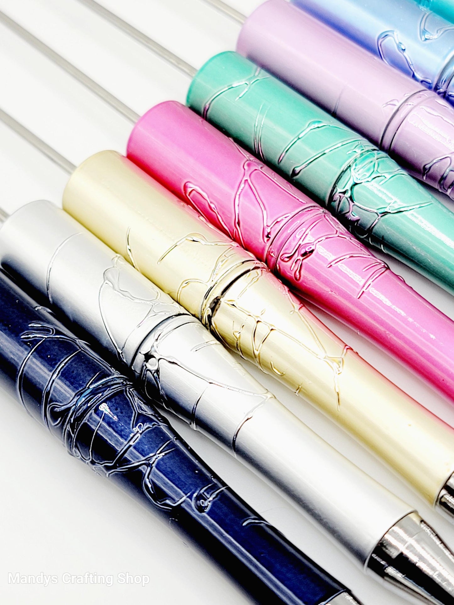Set of colorful pens with metallic sheen on a white background