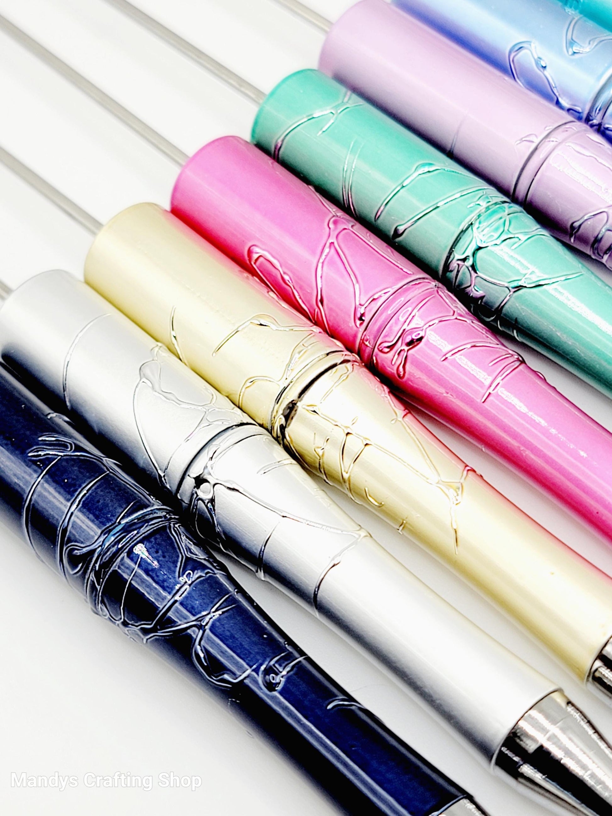 Set of colorful pens with metallic sheen on a white background