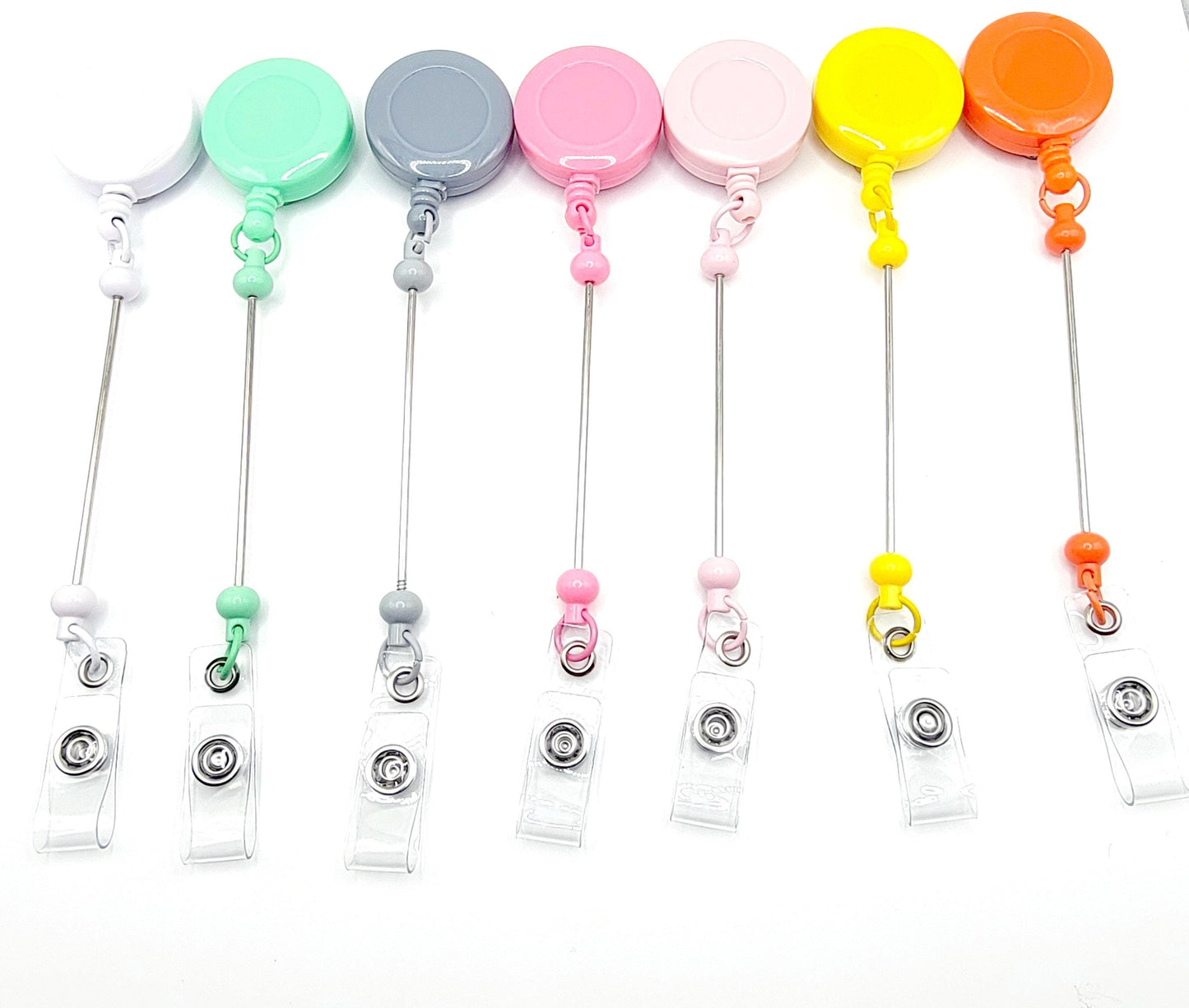 Set of colorful badge holders with various color-coded reels on a white background