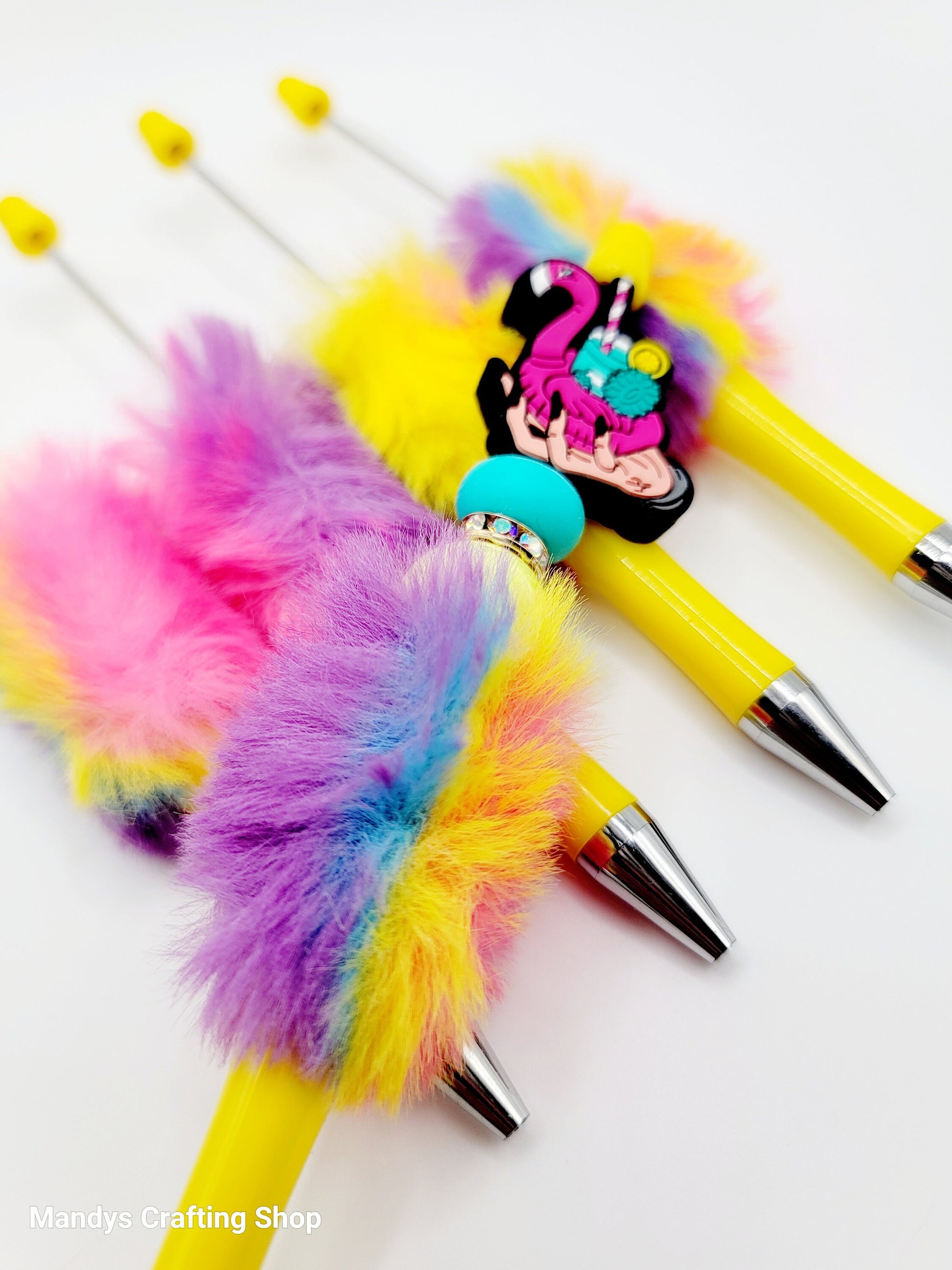 Colorful pens with fluffy accents and a cartoon character on a white background