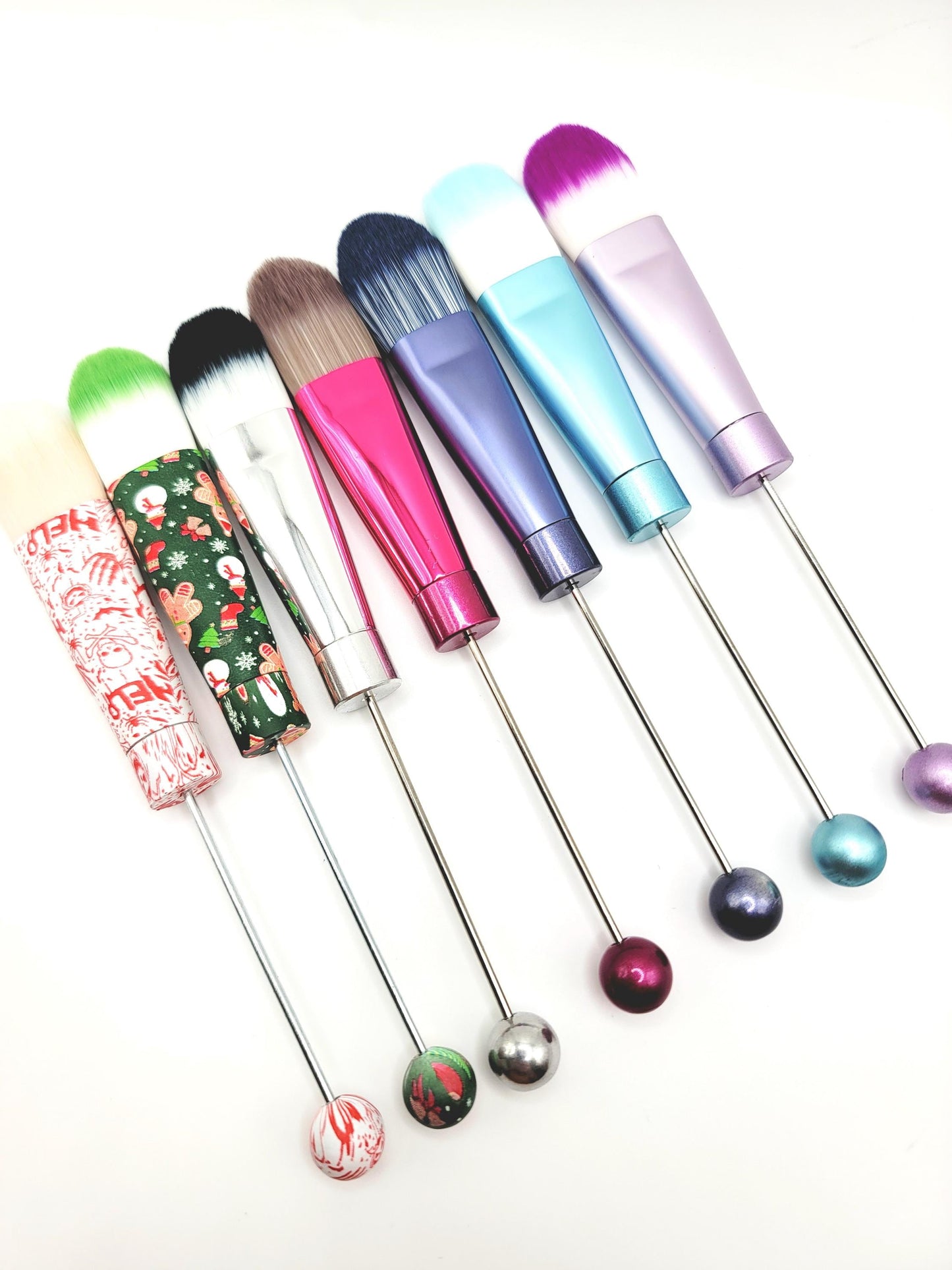 Set of colorful makeup brushes with decorative handles on a white background