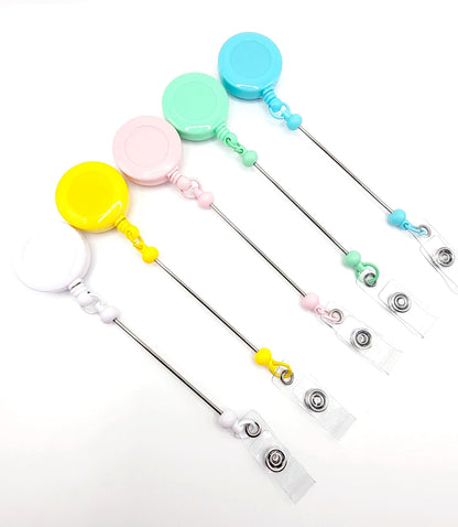 Set of colorful badge holders with retractable strings on a white background