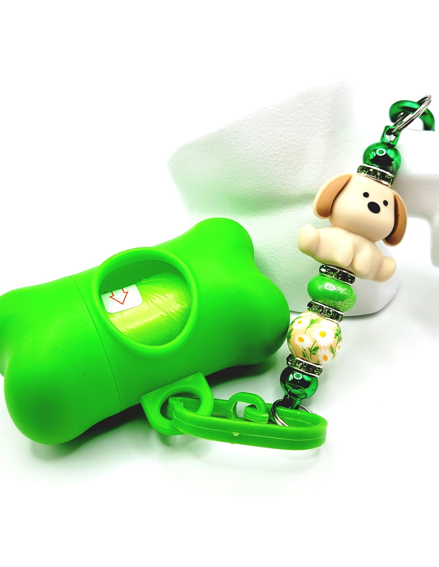 Green dog training clicker with a decorative keychain on a white background