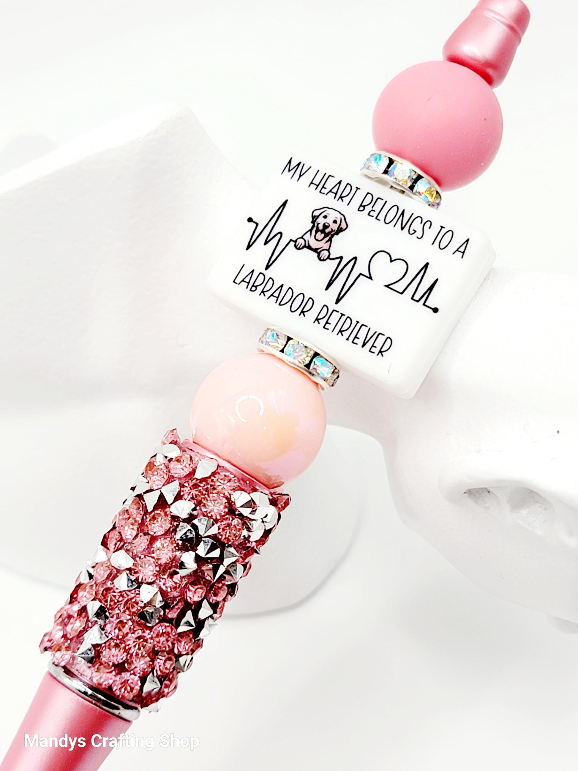 Pink and silver decorative item with text on a white background