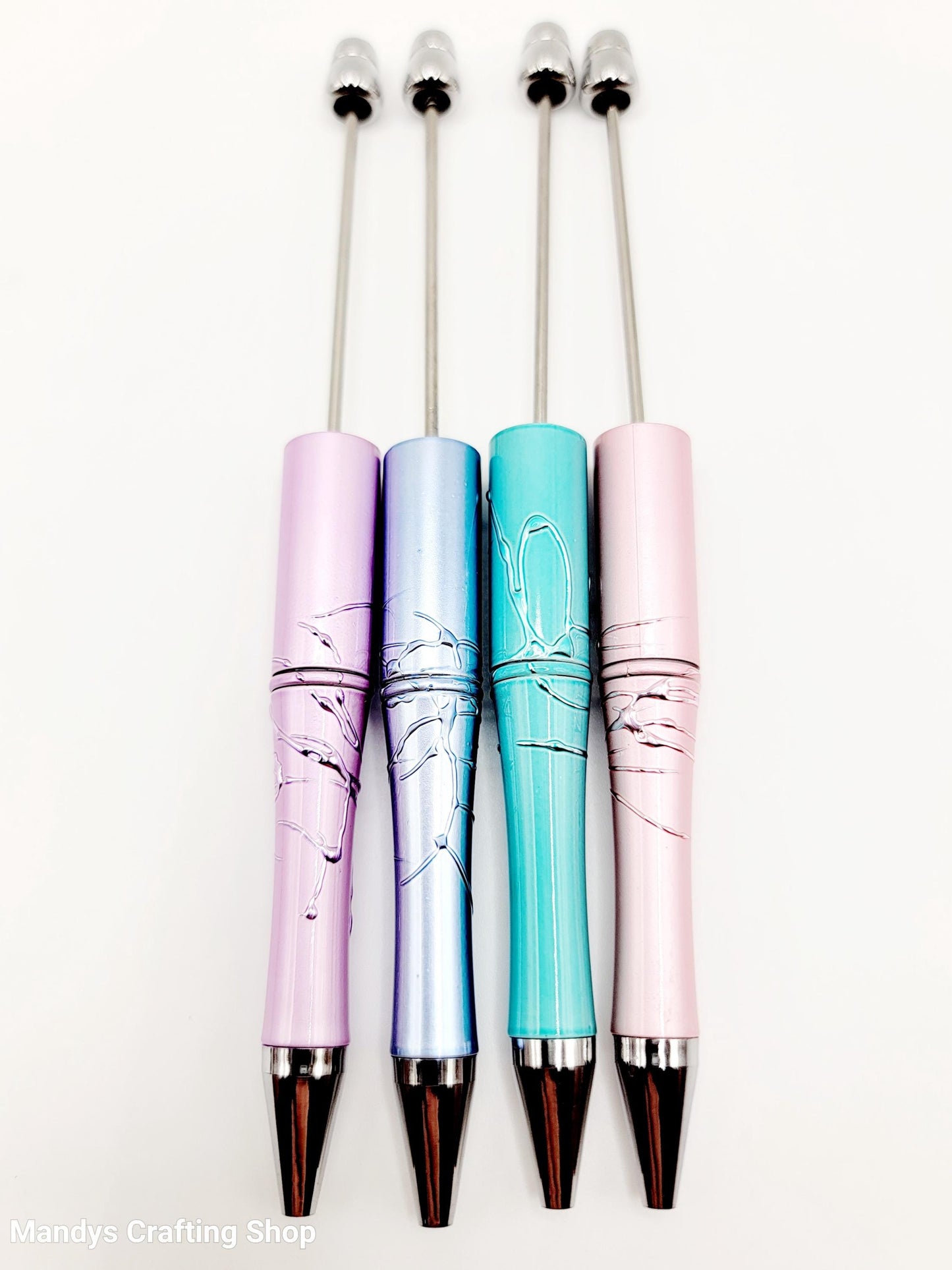 Four colorful pens with marble design on a white background