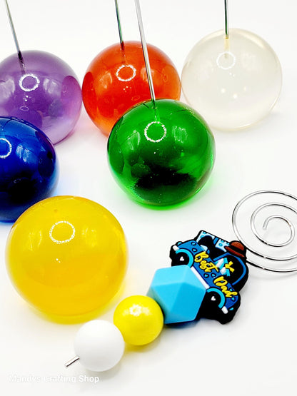 Colorful glass beads and a keychain with text on a white background