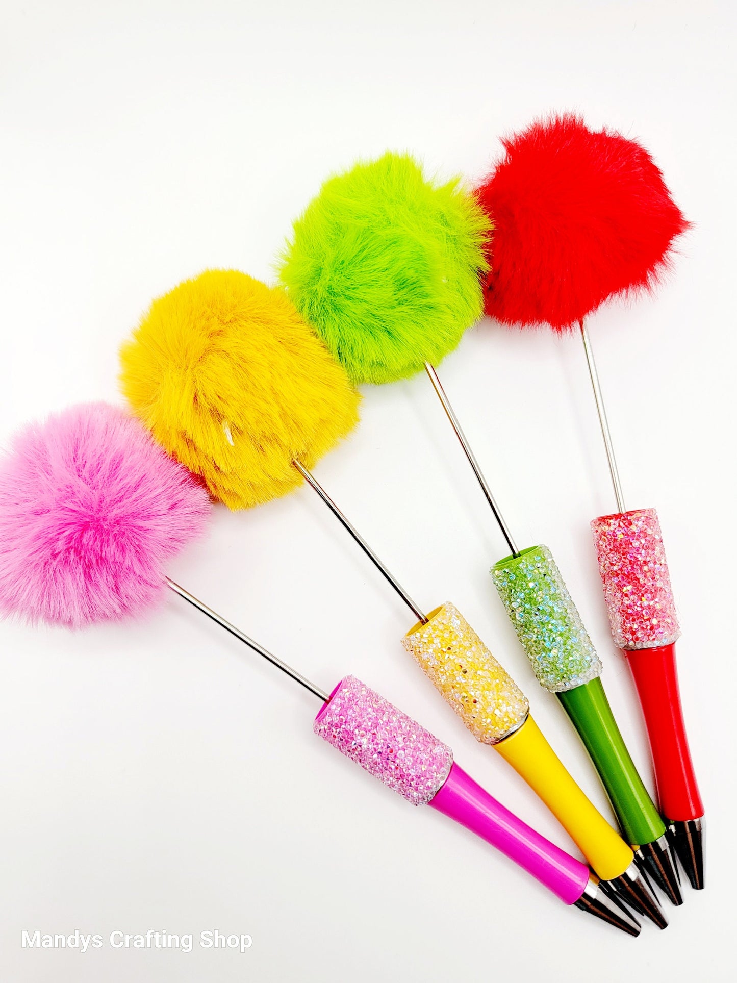 Colorful fluffy sticks with pom-poms on a white background