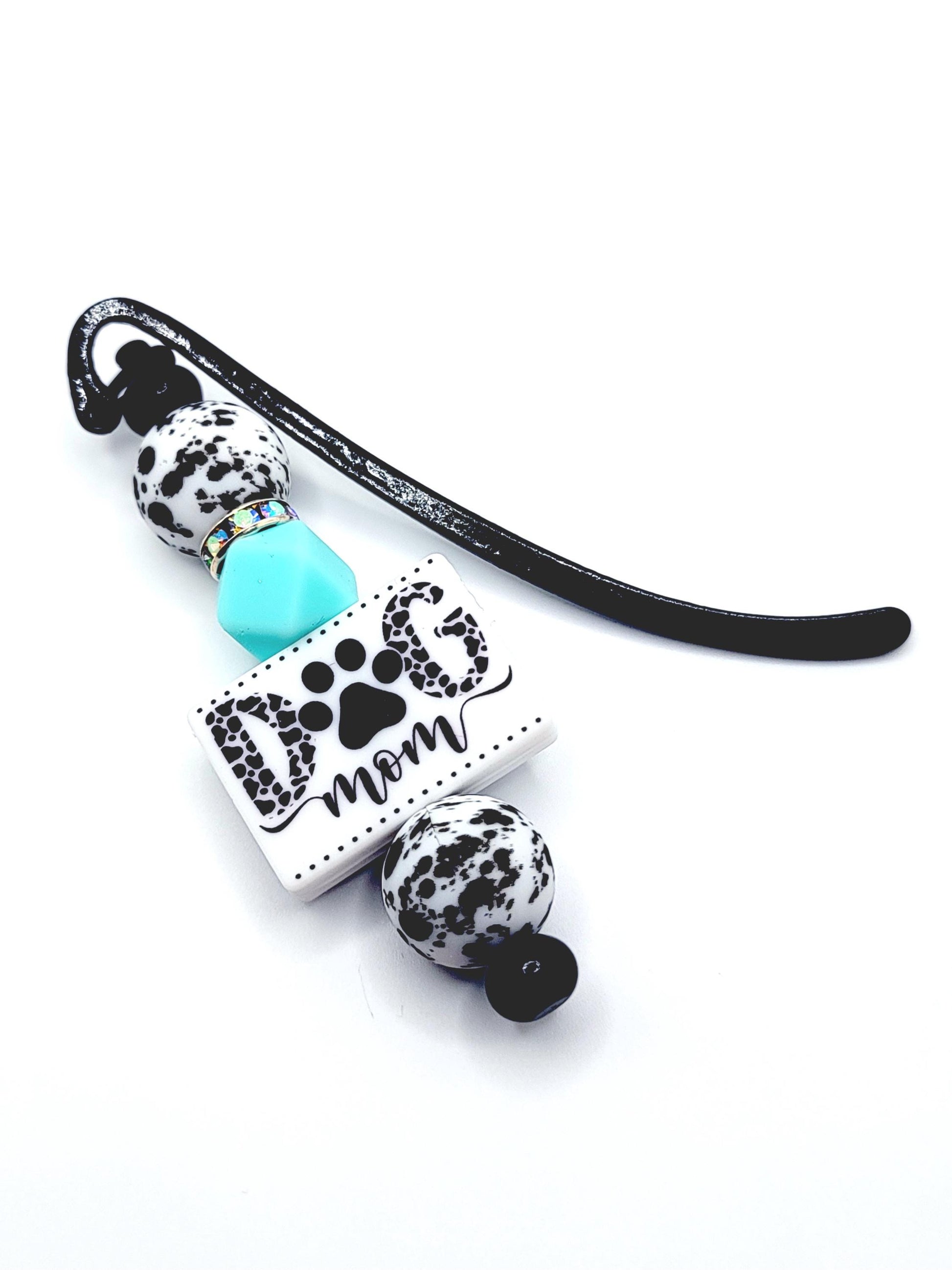 Dog mom charm with black and white paw prints on a white background