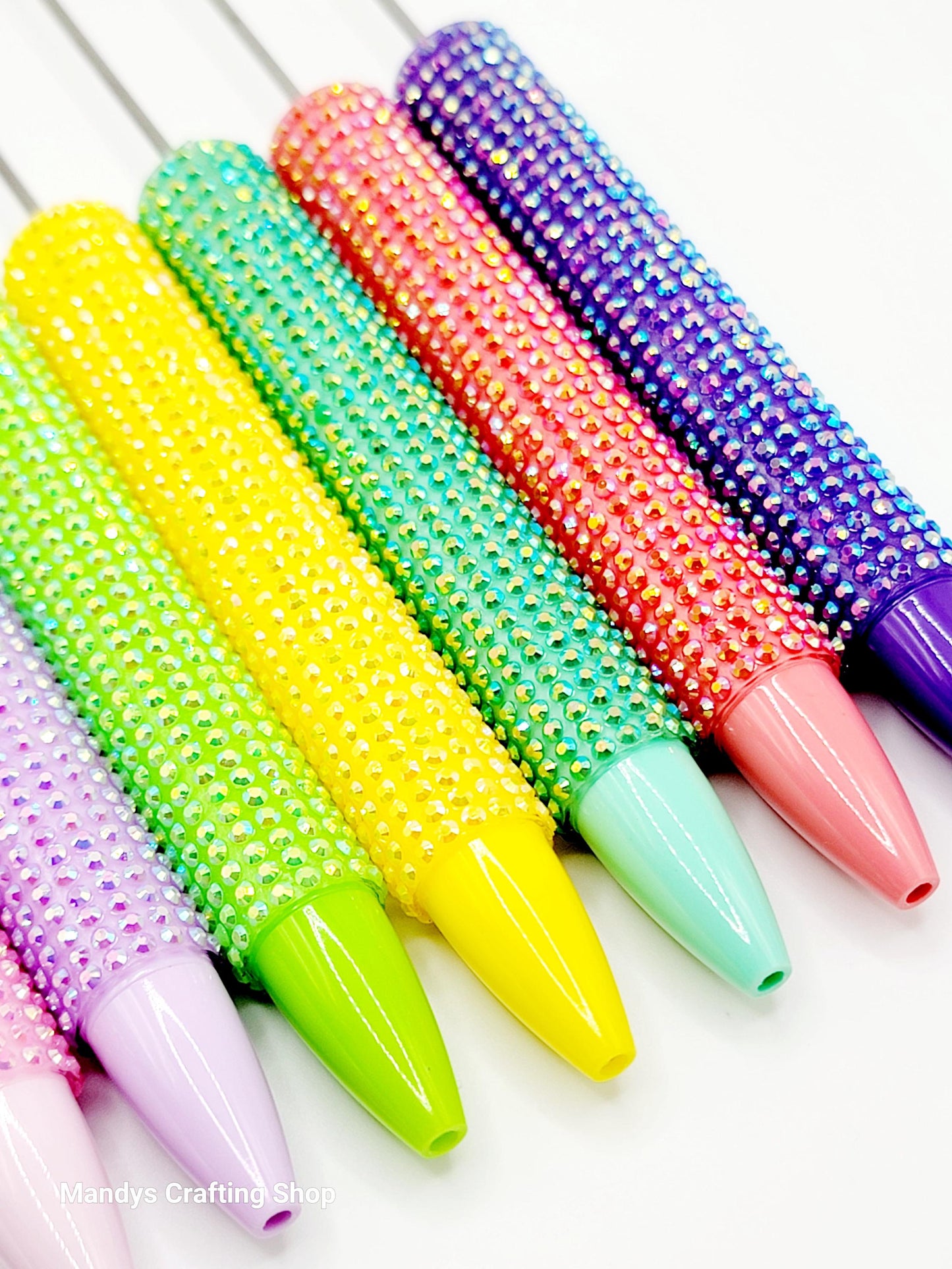 Colorful beaded rolling pins on a white background