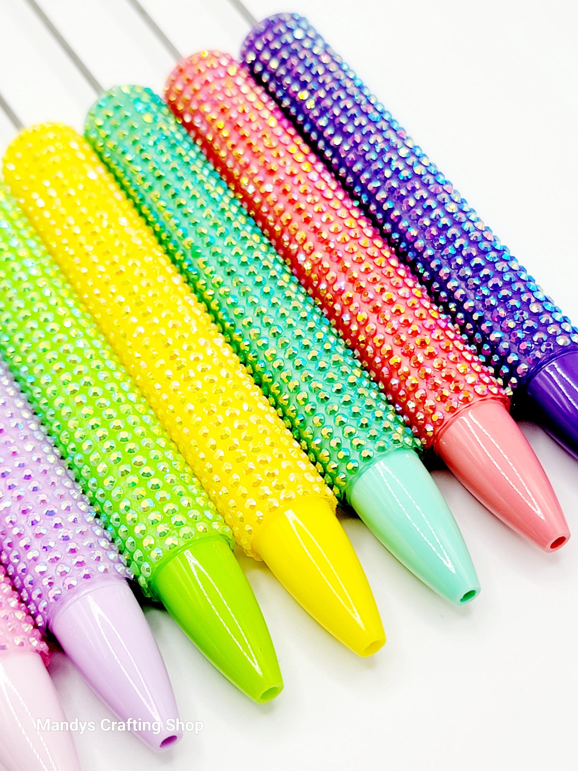 Colorful beaded rolling pins on a white background