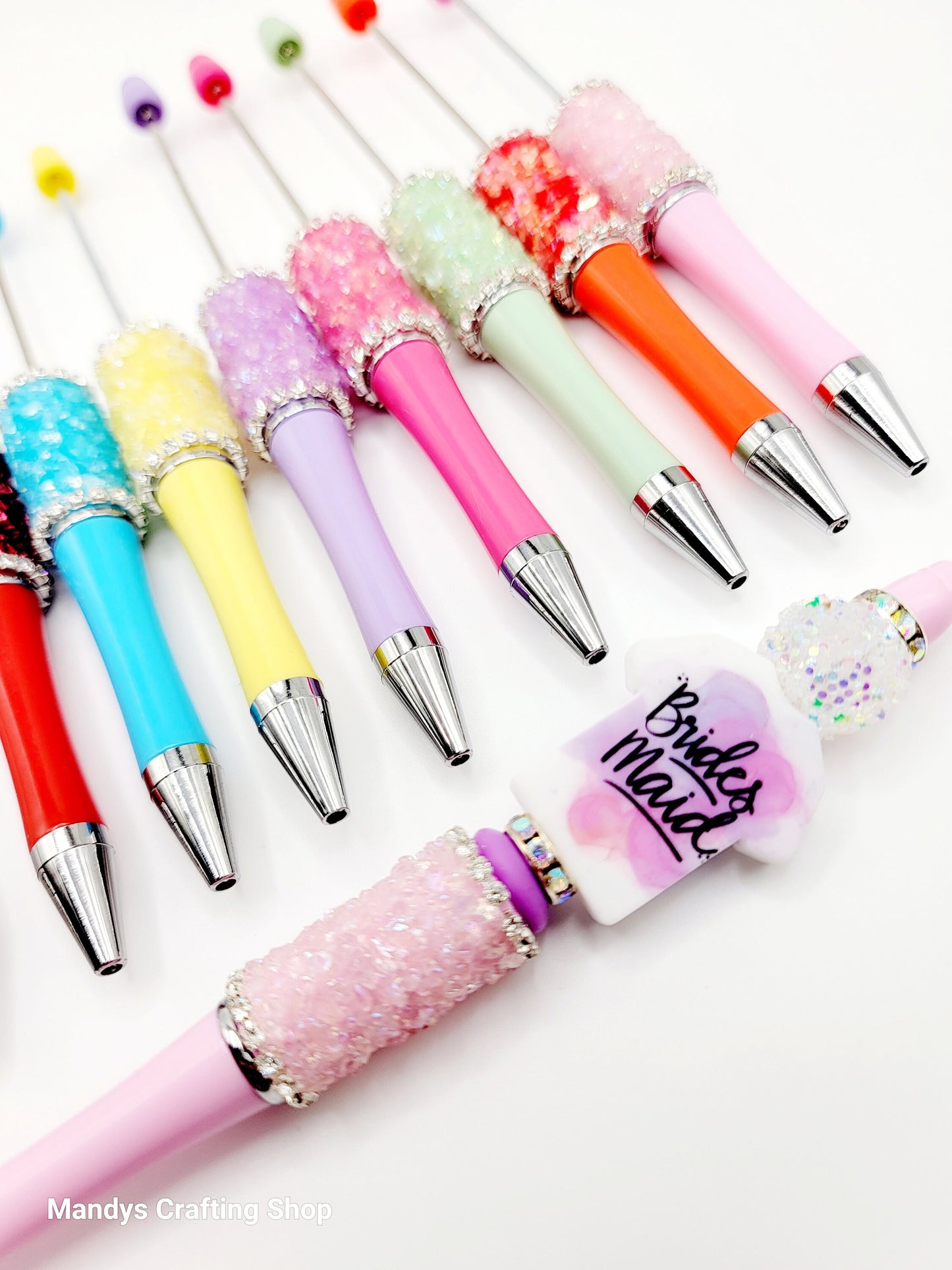 Colorful pens with decorative caps on a white background