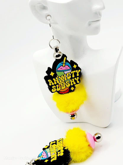 Colorful earrings with pom-poms on a white mannequin.