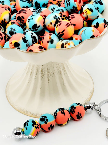 15mm Printed Turquoise, Yellow, & Orange Paw Print Silicone Beads – Round Swirl Paw Print Beads for Pens & Wristlets