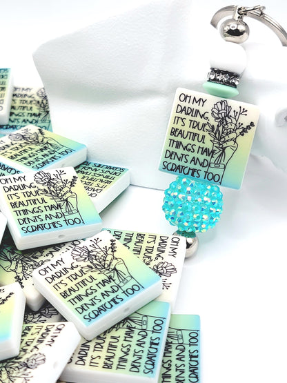 Inspirational focal bead featuring the message “Beautiful Things Have Dents Too” for mental health awareness and DIY beadable pen crafts.