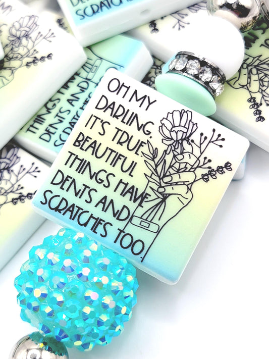 Inspirational focal bead featuring the message “Beautiful Things Have Dents Too” for mental health awareness and DIY beadable pen crafts.