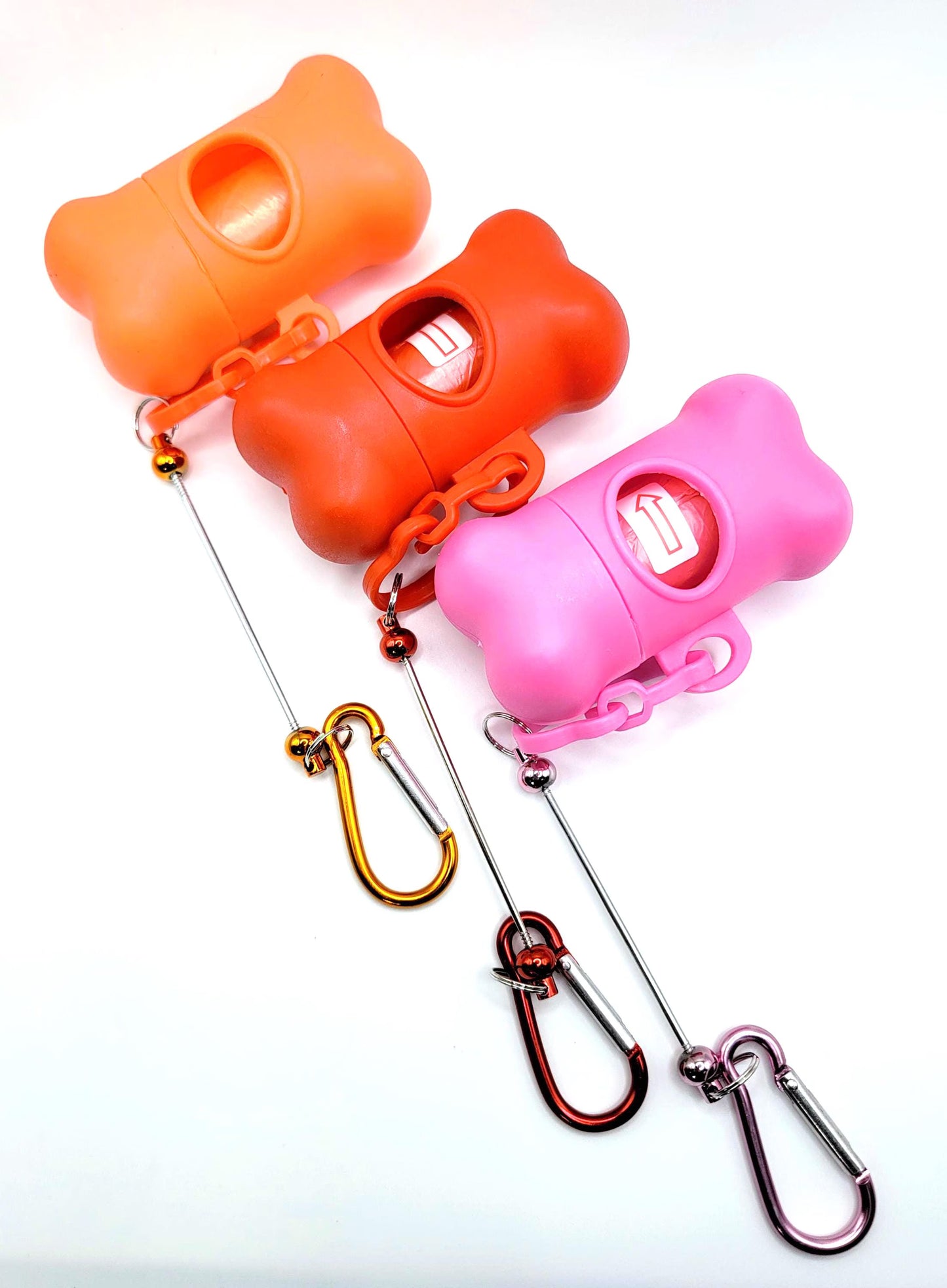 Three colorful dog training clickers with carabiners on a white background