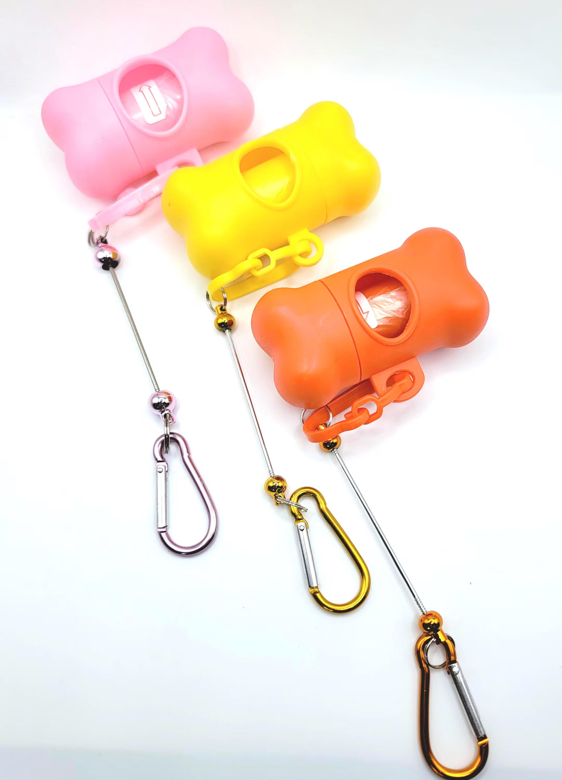 Three colorful dog training clickers with carabiners on a white background
