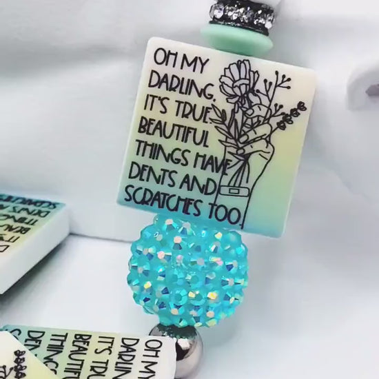 Inspirational focal bead featuring the message “Beautiful Things Have Dents Too” for mental health awareness and DIY beadable pen crafts.